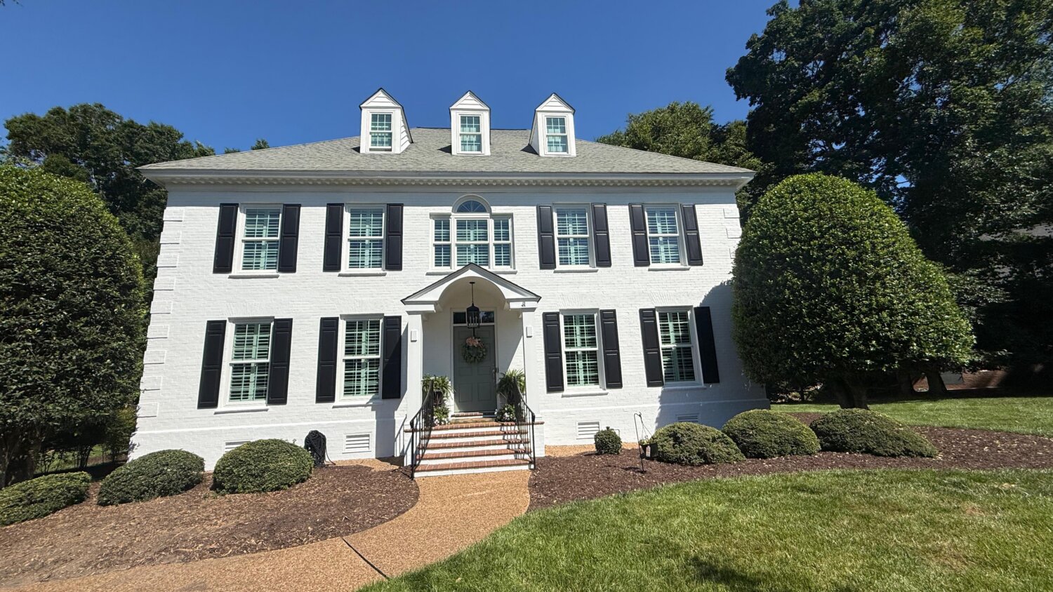 Preparing your home for winter: freshly painted white colonial home with black shutters
