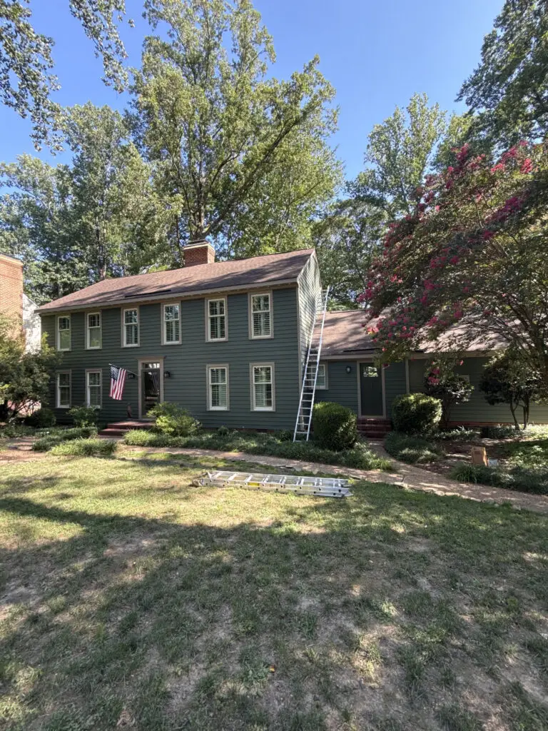 Ladder against a green colonial home during a fall exterior painting project in Williamsburg VA